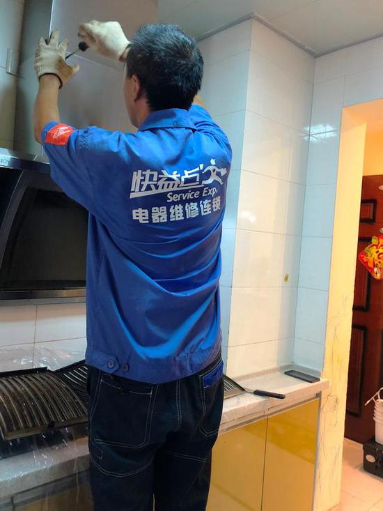(师傅拆卸油烟机外壳)